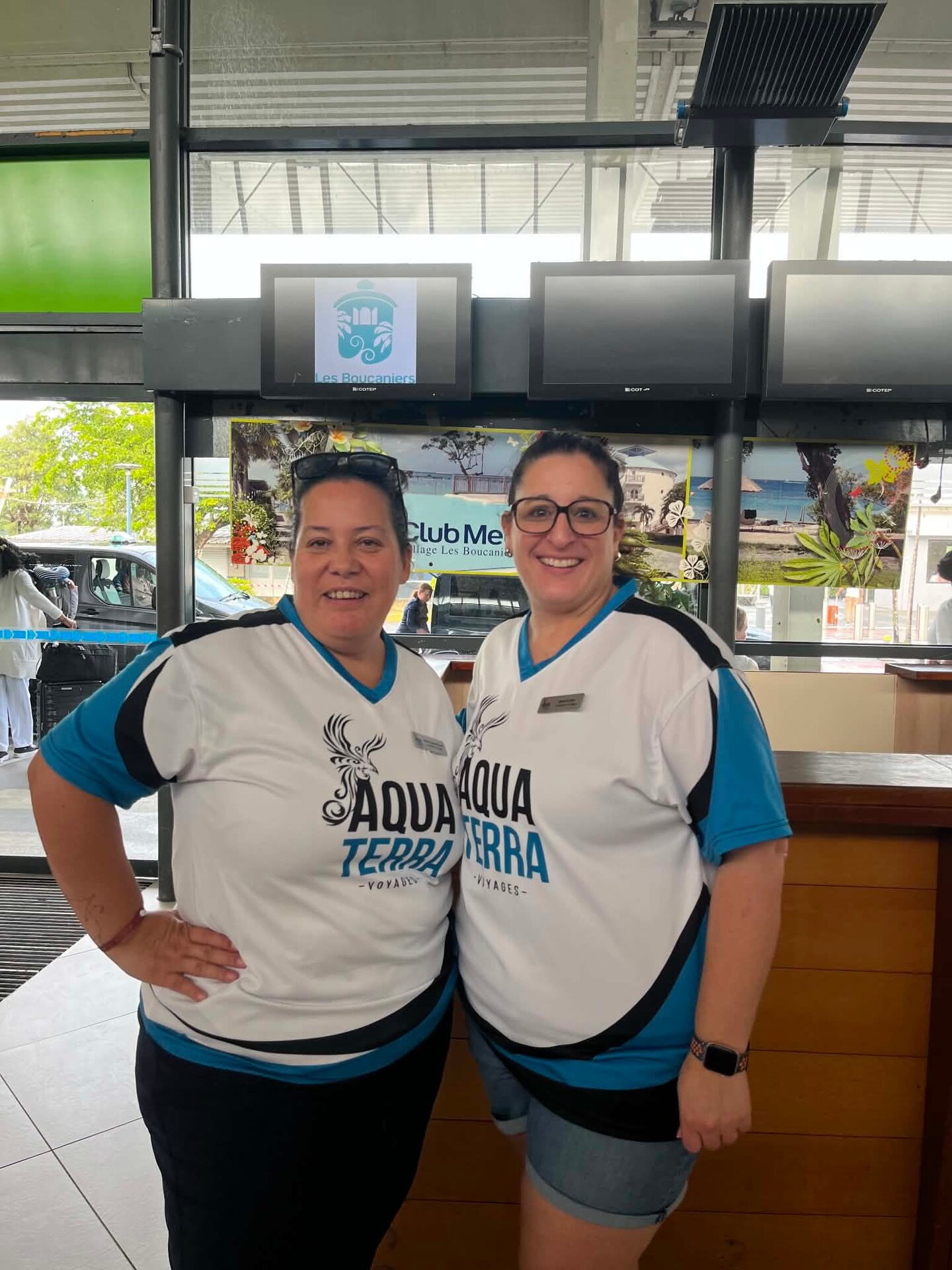 Two AquaTerra advisors in branded shirts at the Martinique airport welcome desk Two AquaTerra advisors in branded shirts at the Martinique airport welcome desk