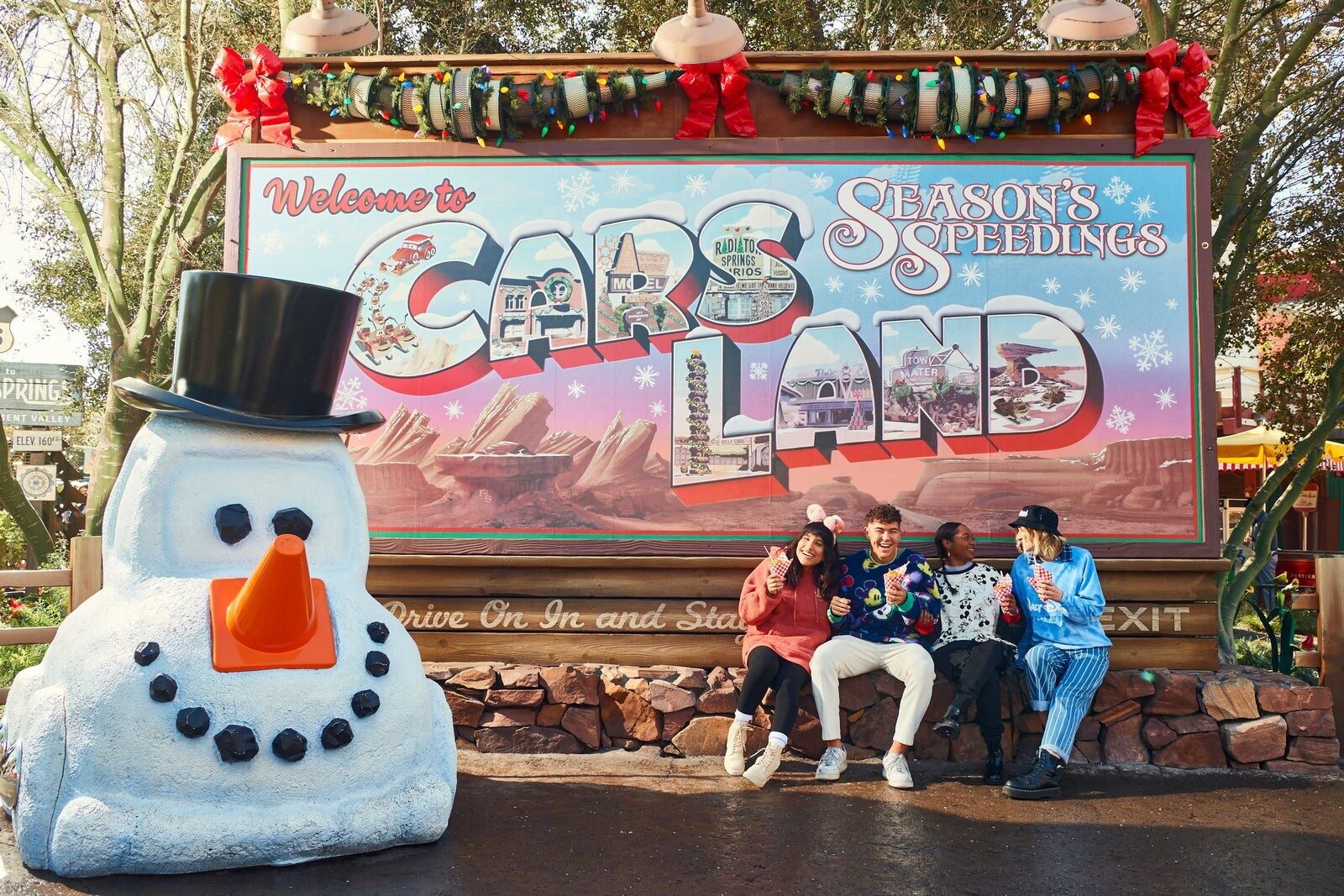 L'enseigne de Cars Land habillée pour la période des Fêtes, avec un bonhomme de neige en pneus L'enseigne de Cars Land habillée pour la période des Fêtes, avec un bonhomme de neige en pneus