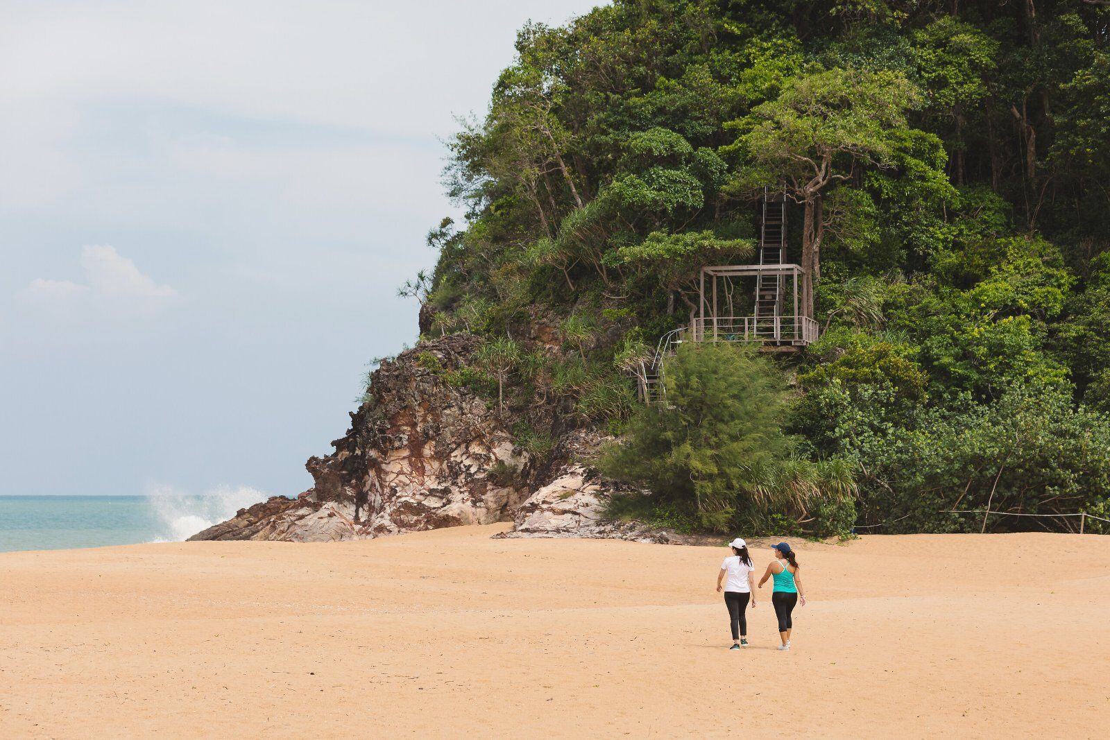 Beach framed by rocks and forest at Club Med Cherating Beach