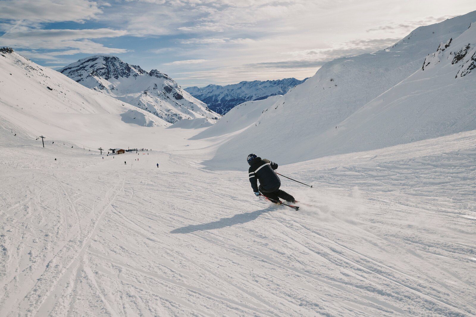 A skier going down a wide high-mountain slope A skier going down a wide high-mountain slope