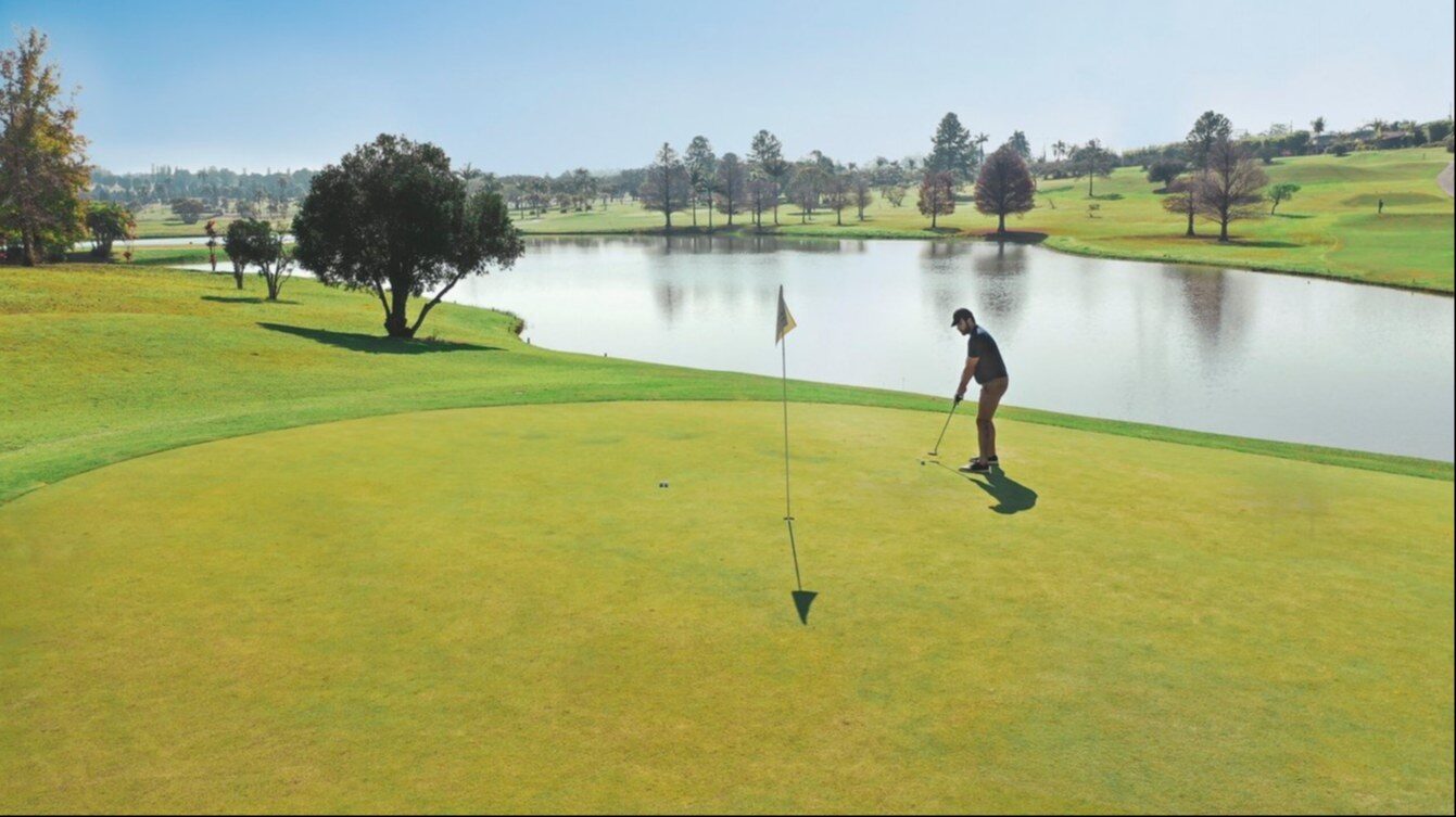 A golfer on a lakeside green at Club Med Lake Paradise A golfer on a lakeside green at Club Med Lake Paradise