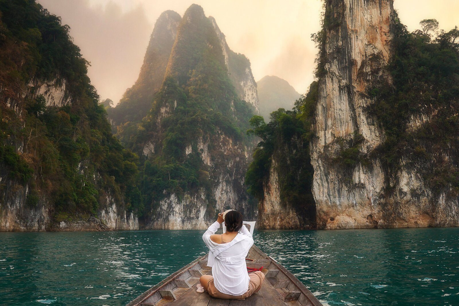 Boat on Cheow Lan Lake between the cliffs of Khao Sok