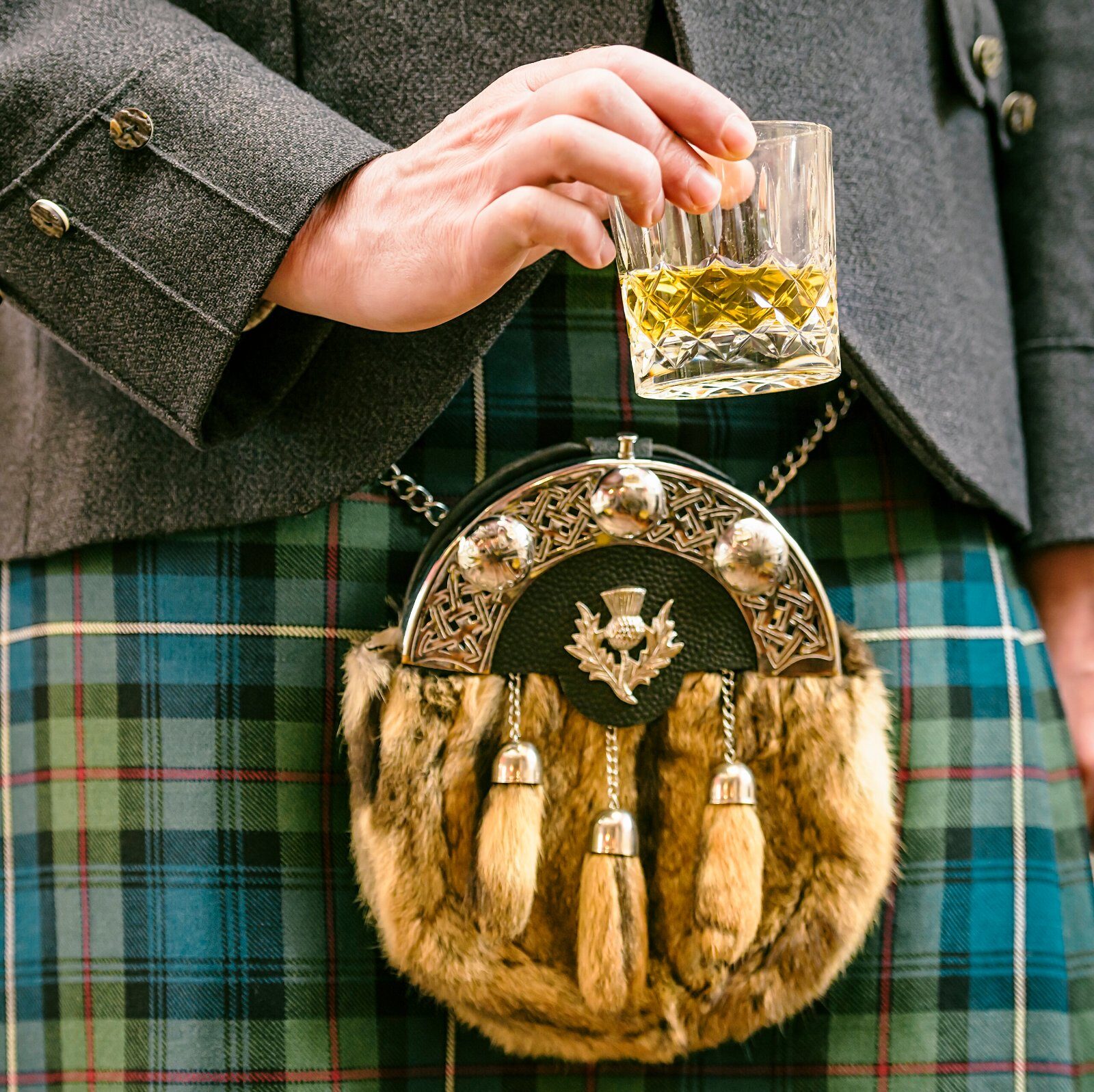 Glass of whisky and traditional Scottish dress