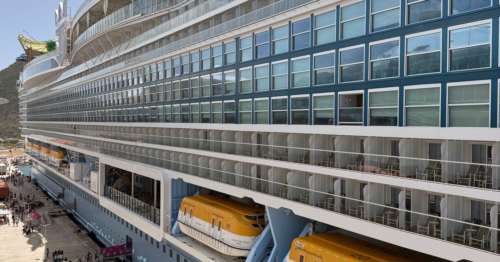 Large cruise ship docked at the pier, side profile, illustrating the real cost of a cruise