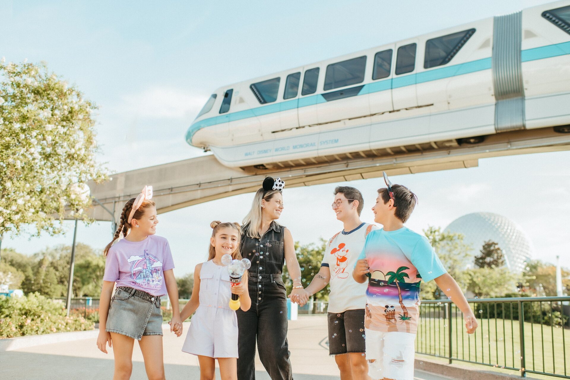 A family walks beneath the Walt Disney World monorail near the EPCOT entrance in Florida
