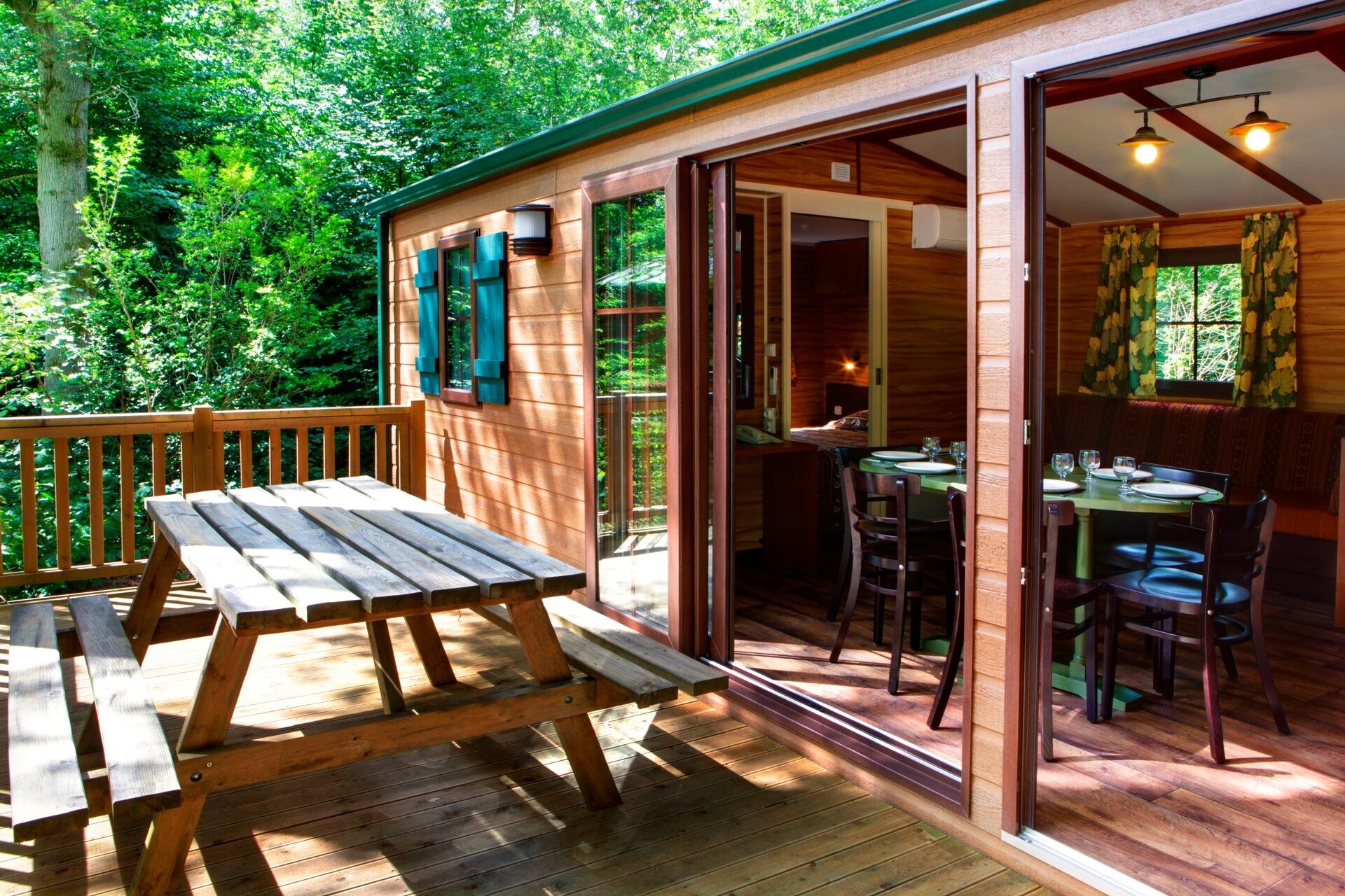 The deck of a bungalow at Disney Davy Crockett Ranch, with a wooden picnic table in the middle of the forest. Photo: ©Disney. The deck of a bungalow at Disney Davy Crockett Ranch, with a wooden picnic table in the middle of the forest. Photo: ©Disney.