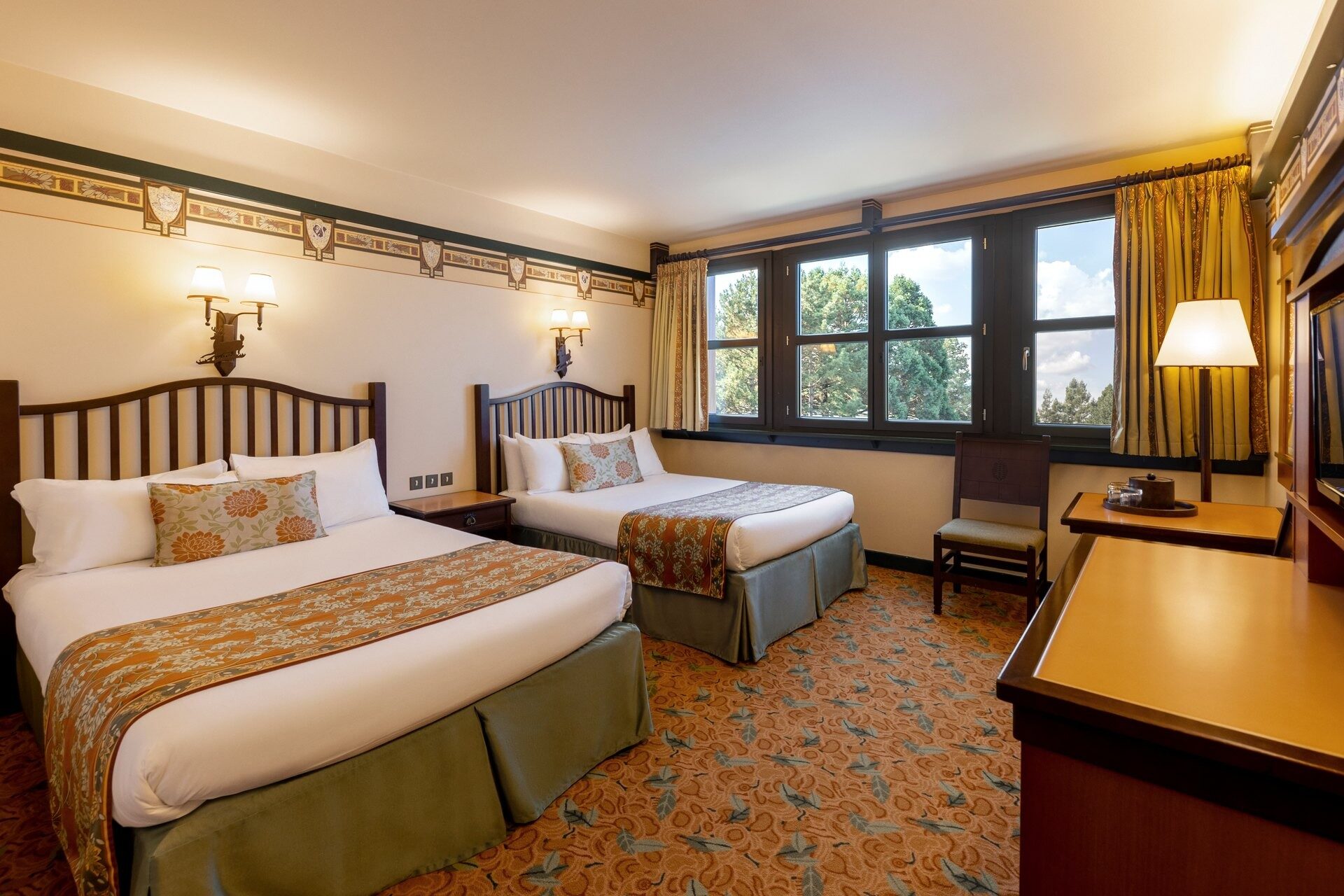 Une chambre Standard du Disney Sequoia Lodge, avec deux grands lits, des boiseries et des fenêtres ouvertes sur les arbres. Photo : ©Disney. Une chambre Standard du Disney Sequoia Lodge, avec deux grands lits, des boiseries et des fenêtres ouvertes sur les arbres. Photo : ©Disney.