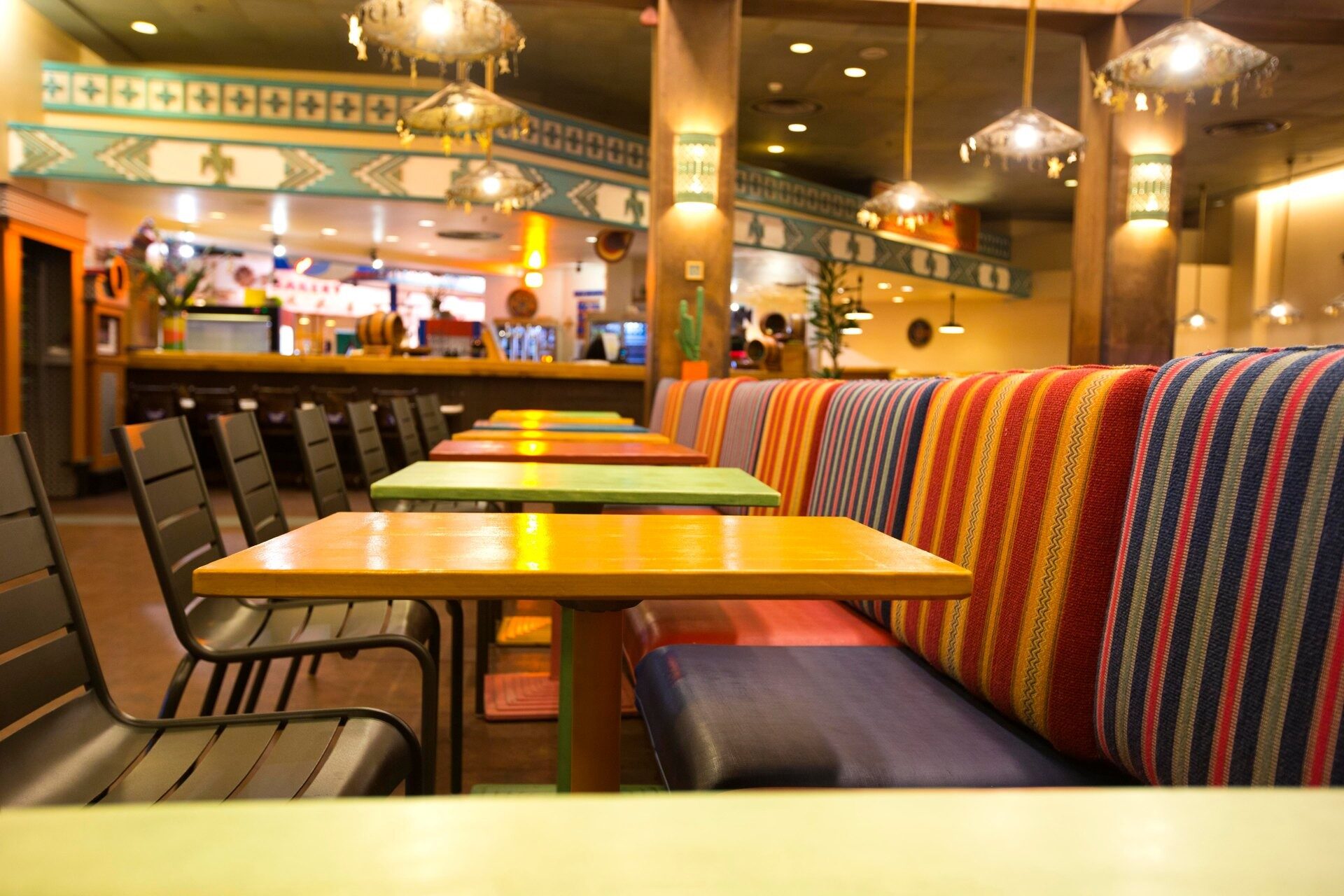 La salle de La Cantina, au Disney Hotel Santa Fe, avec ses banquettes aux rayures vives et ses tables jaunes. Photo : ©Disney. La salle de La Cantina, au Disney Hotel Santa Fe, avec ses banquettes aux rayures vives et ses tables jaunes. Photo : ©Disney.