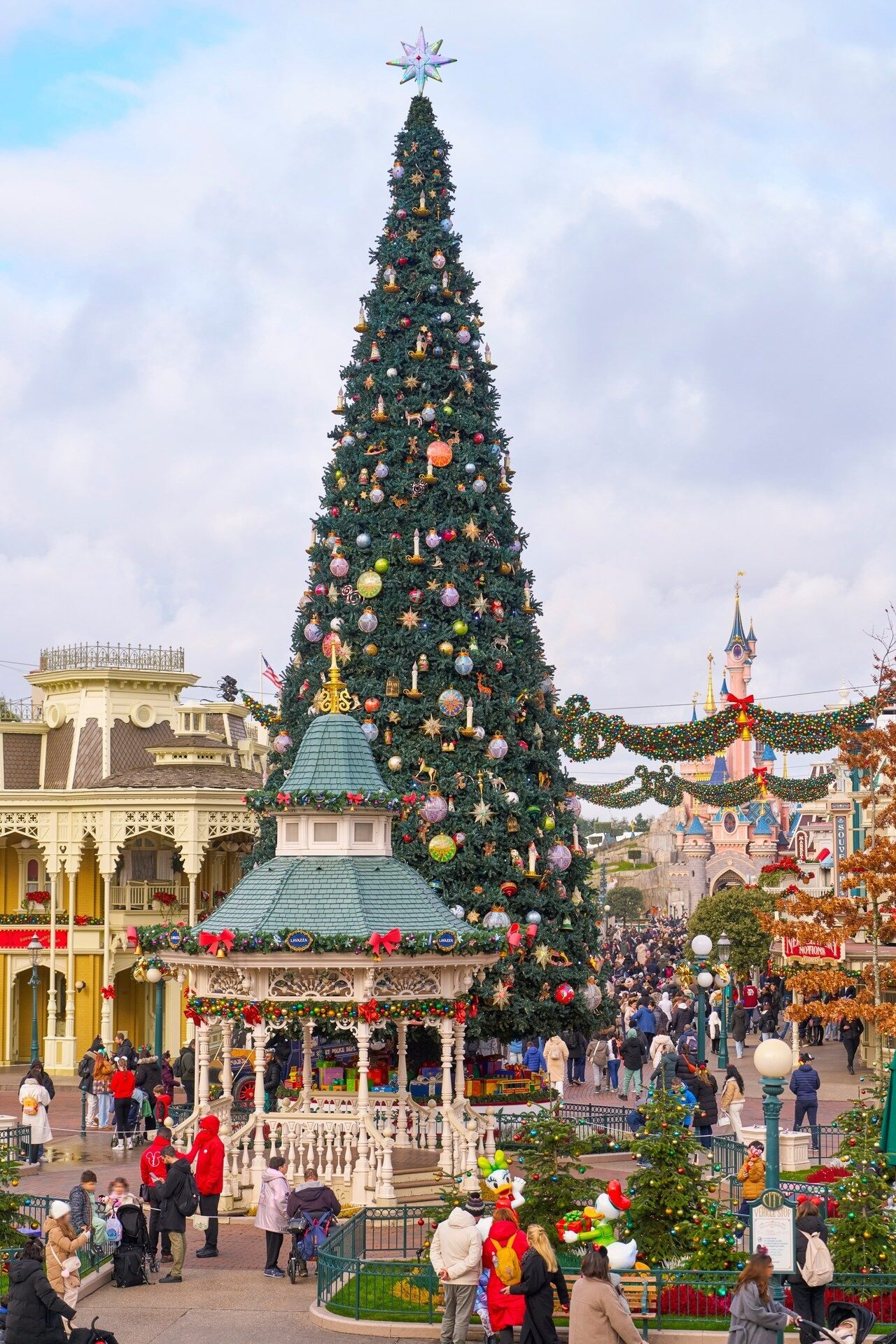The giant Christmas tree in Town Square at the entrance to Disneyland Park, surrounded by the decorated facades of Main Street, U.S.A. Photo: ©Disney.