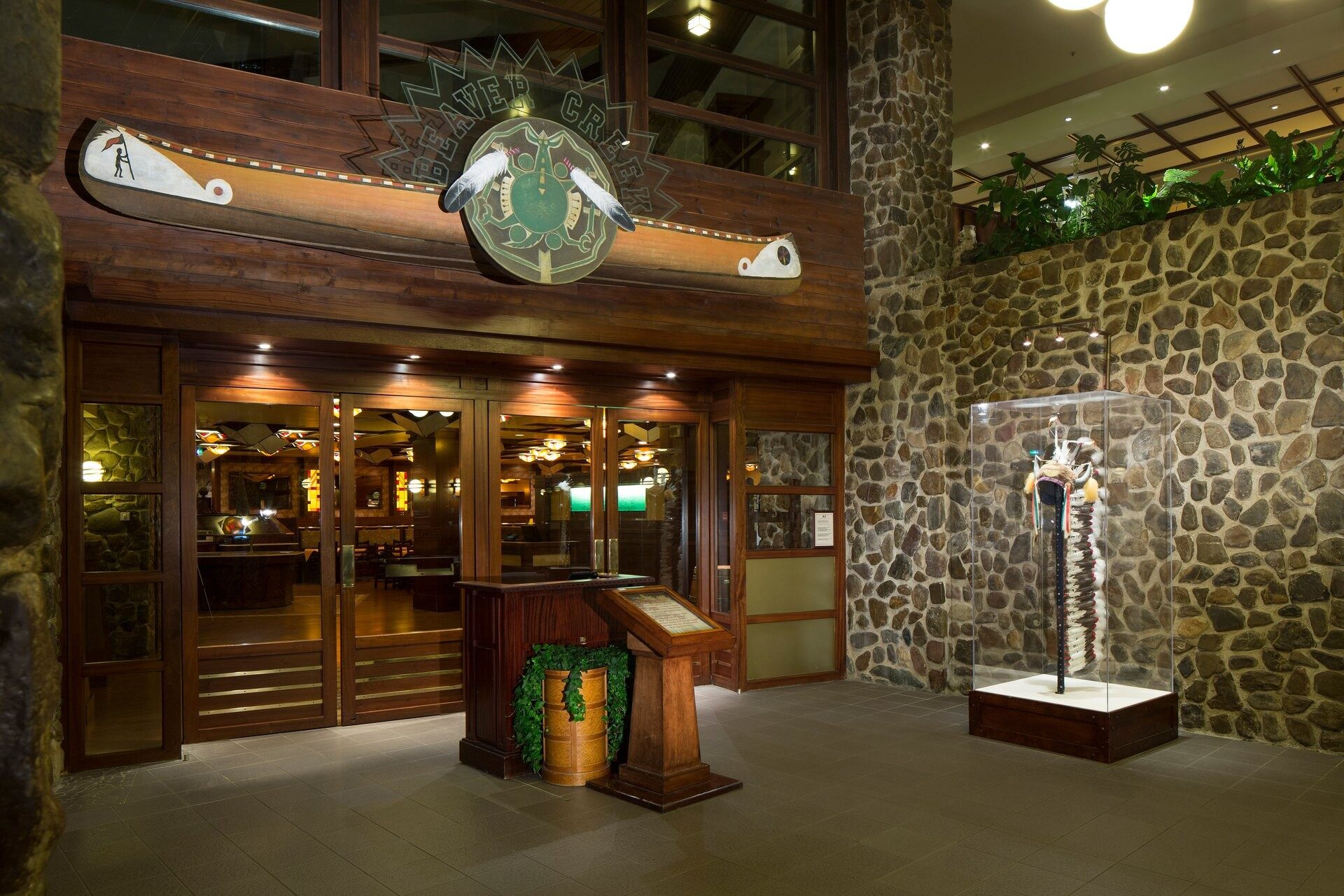 L'entrée du restaurant Beaver Creek Tavern, au Disney Sequoia Lodge, avec son mur de galets, son totem et son grand emblème en bois. Photo : ©Disney. L'entrée du restaurant Beaver Creek Tavern, au Disney Sequoia Lodge, avec son mur de galets, son totem et son grand emblème en bois. Photo : ©Disney.