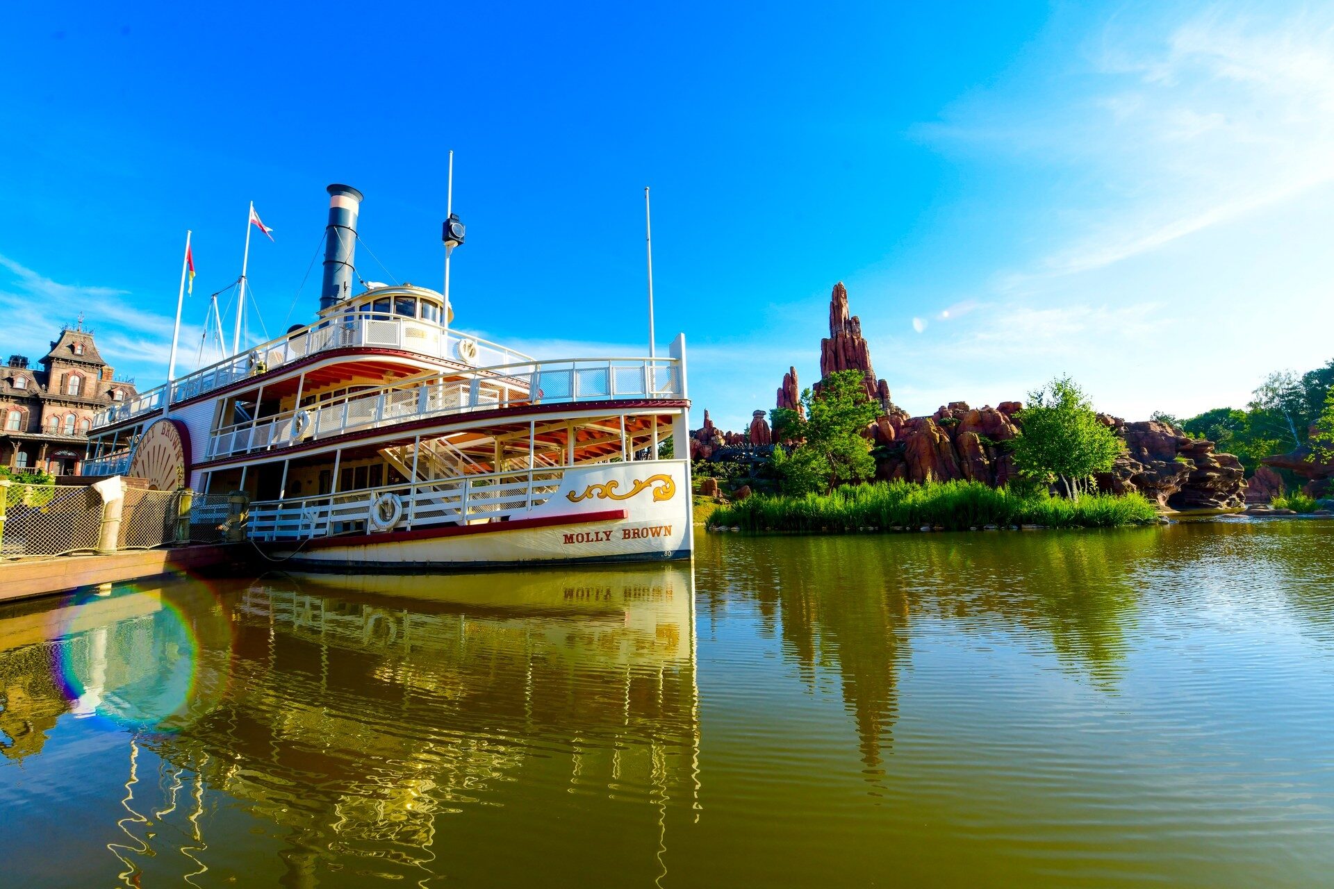 Le bateau à aubes de Thunder Mesa amarré sur les Rivers of the Far West, à Frontierland, avec les rochers de Big Thunder Mountain au loin. Photo : ©Disney. Le bateau à aubes de Thunder Mesa amarré sur les Rivers of the Far West, à Frontierland, avec les rochers de Big Thunder Mountain au loin. Photo : ©Disney.