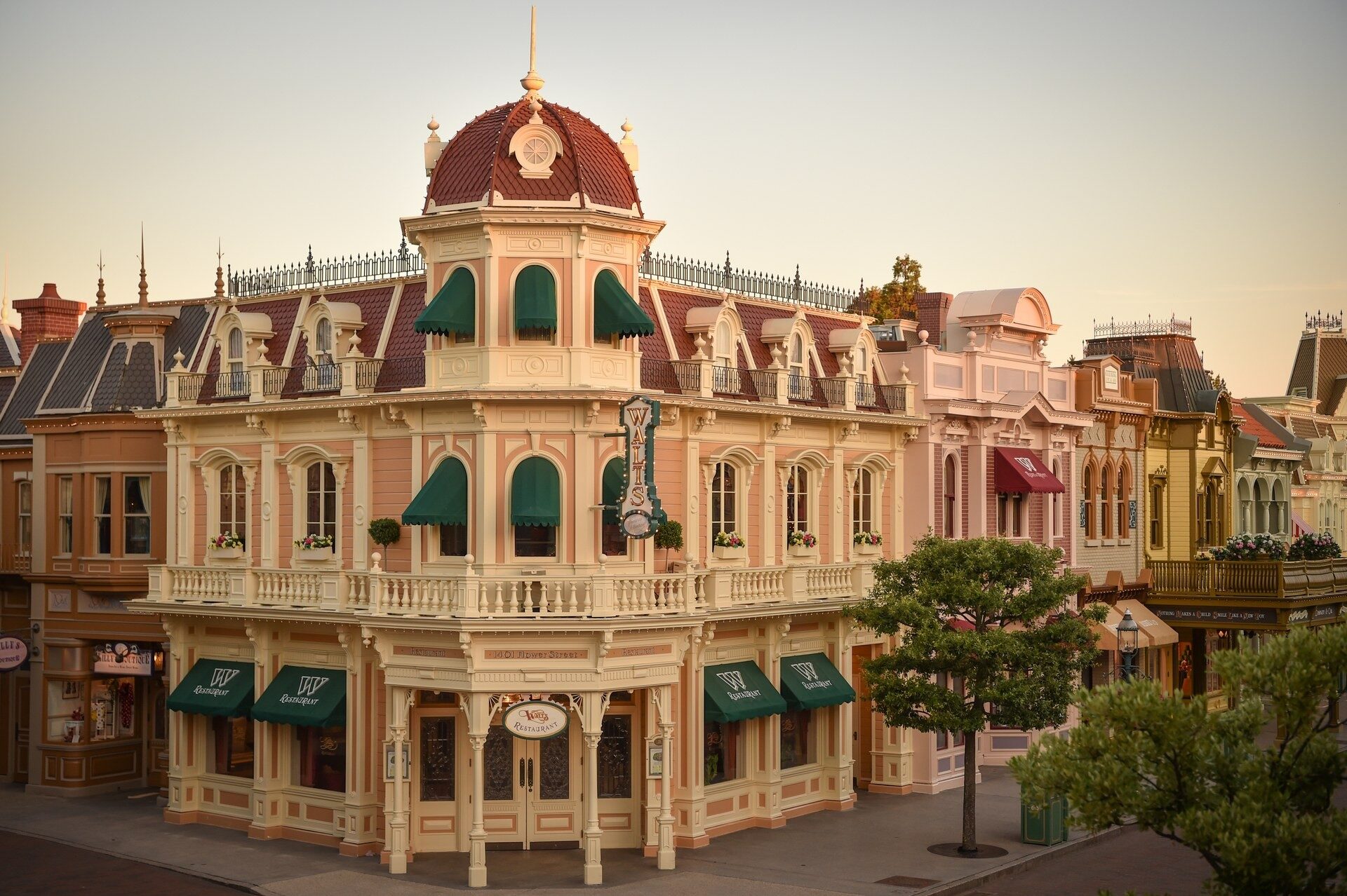 The facade of Walt's – an American Restaurant on Main Street, U.S.A. in Disneyland Park, with its balconies and red dome. Photo: ©Disney.