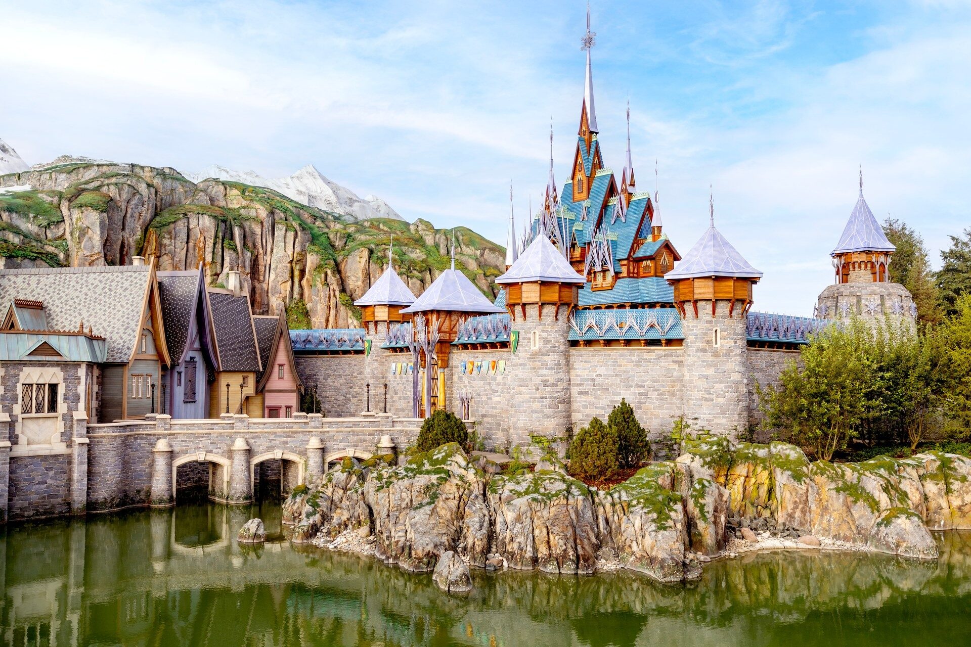 Le château d'Arendelle et le village de World of Frozen, à Disney Adventure World, reflétés dans le lac au pied de la montagne. Photo : ©Disney. Le château d'Arendelle et le village de World of Frozen, à Disney Adventure World, reflétés dans le lac au pied de la montagne. Photo : ©Disney.