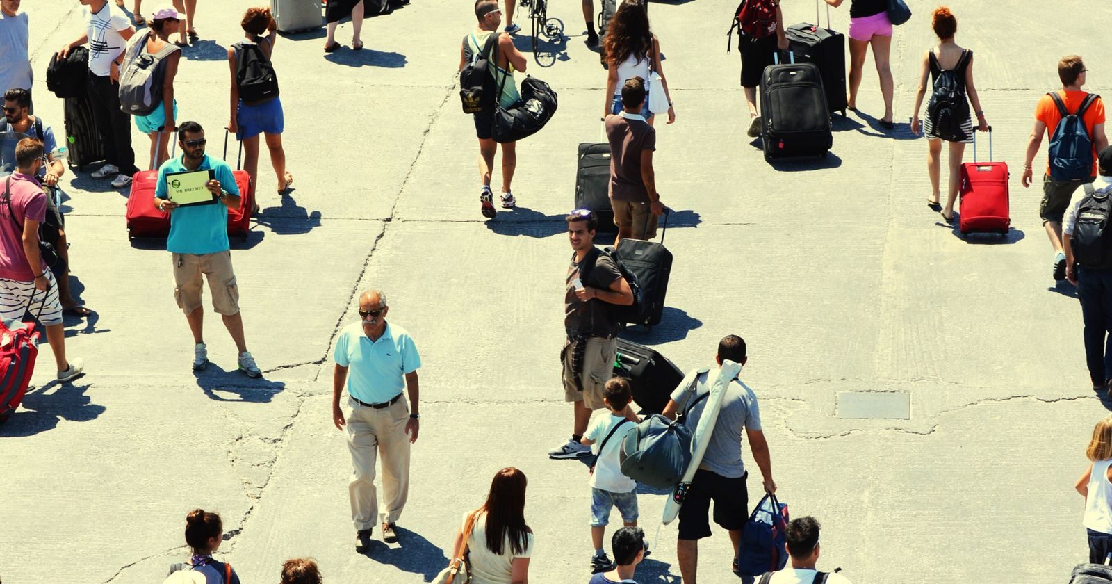 Passengers walking to the terminal with their suitcases on cruise embarkation day