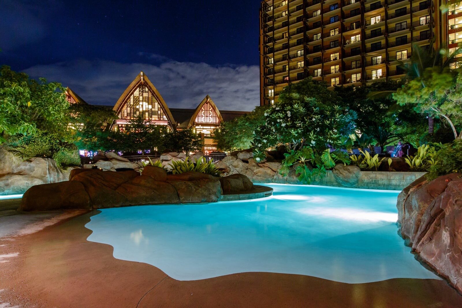 La piscine de la vallée Waikolohe illuminée à la tombée du jour, à Aulani La piscine de la vallée Waikolohe illuminée à la tombée du jour, à Aulani