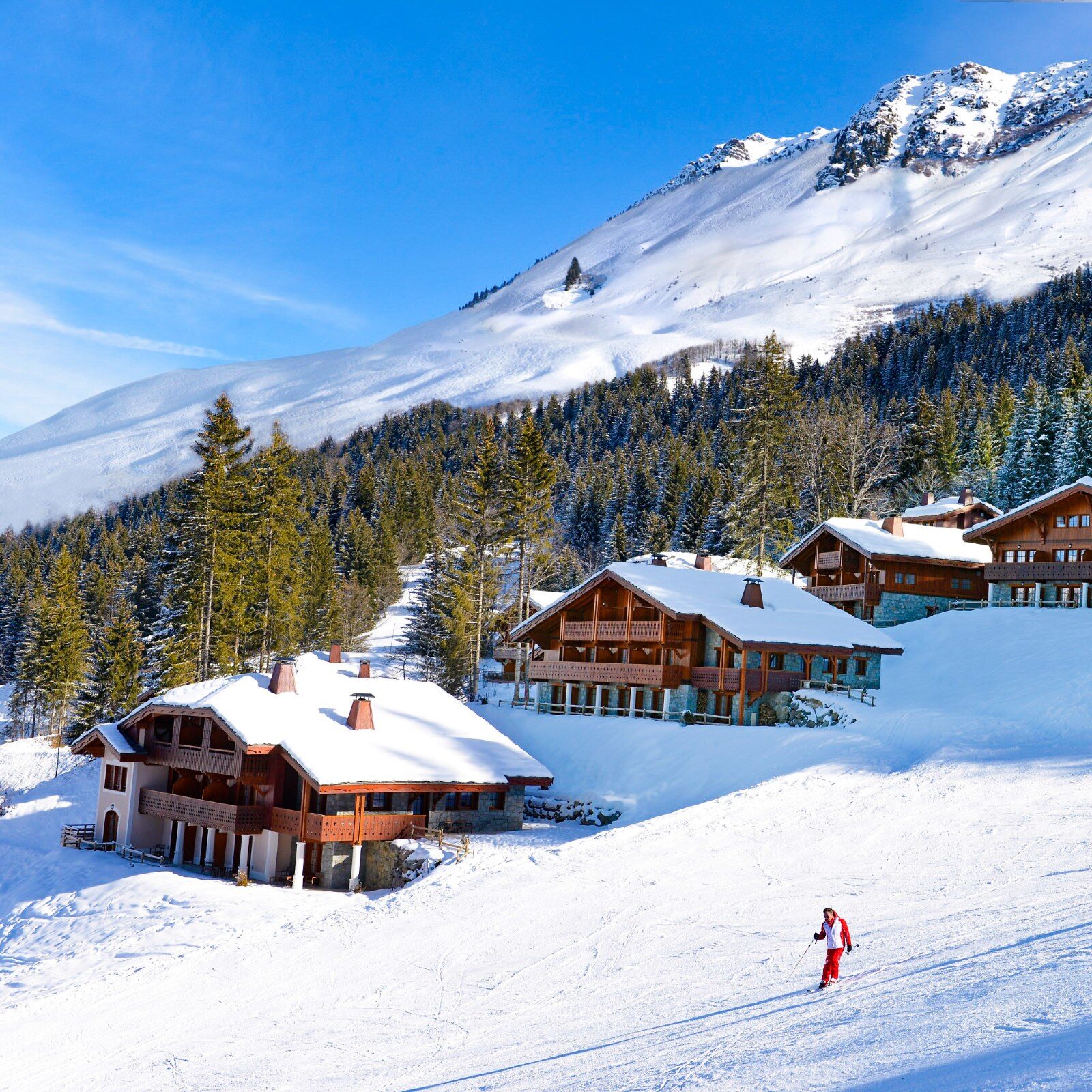 Chalets sous la neige dans une forêt des Alpes Chalets sous la neige dans une forêt des Alpes