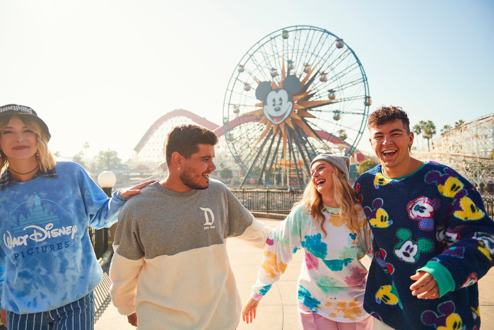Un groupe d'amis marche le long de Pixar Pier, la grande roue en arrière-plan Un groupe d'amis marche le long de Pixar Pier, la grande roue en arrière-plan